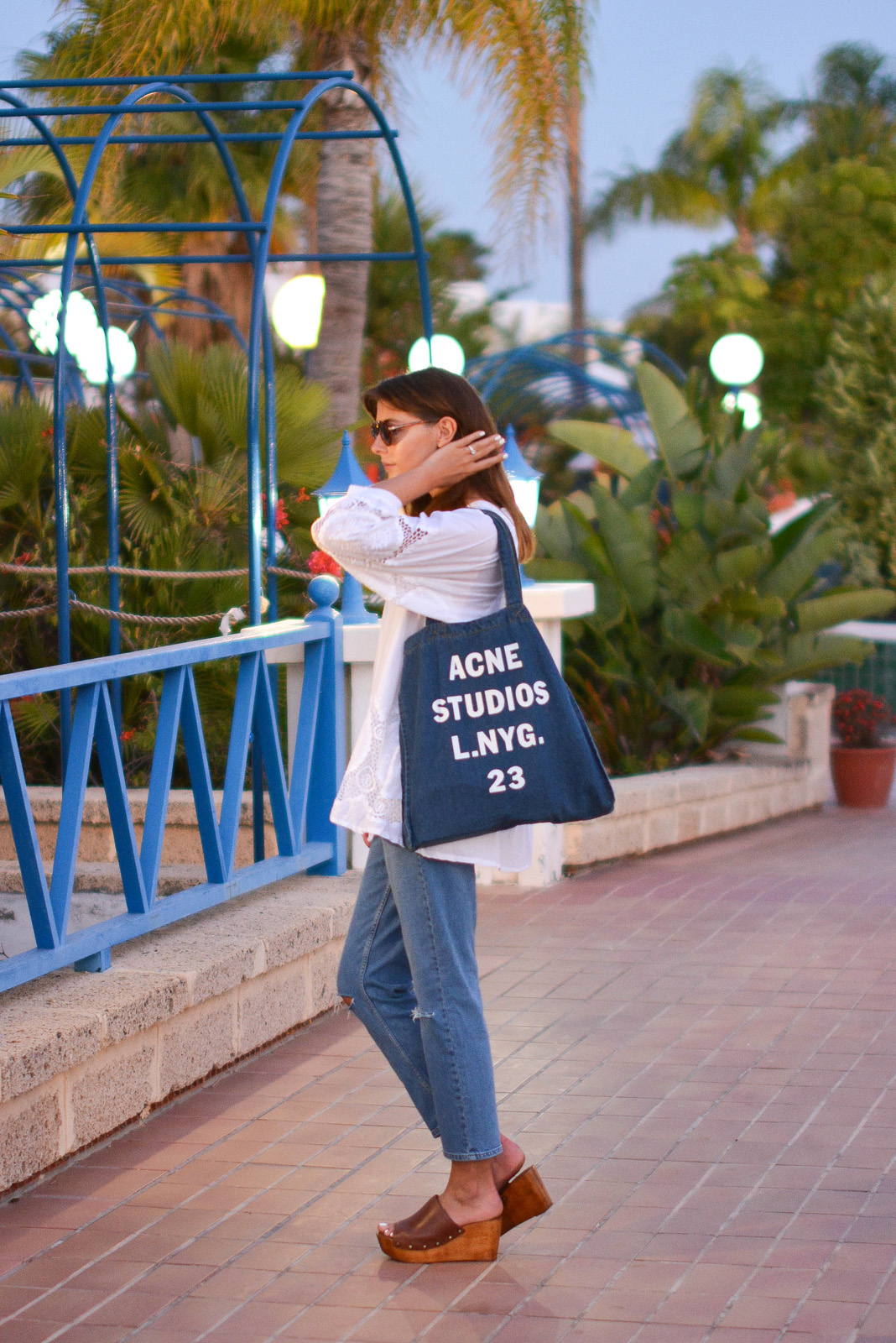 EJSTYLE - Emma Hill wears Acne Studios printed denim tote bag, white summer top with cut out embroidered detail, mASOS thea girlfriend jeans, Dune Keera wedge sandals, Asos aviator sunglasses