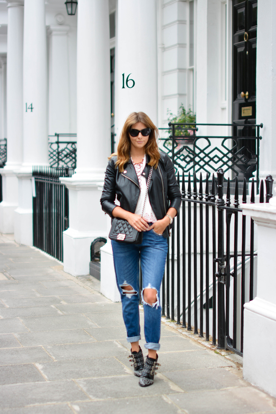 EJSTYLE - Emma Hill wears ripped boyfriend jeans, leather jacket, embroidered lace up top, chanel boy bag, studded black ankle boots, black cats eye sunglasses, OOTD