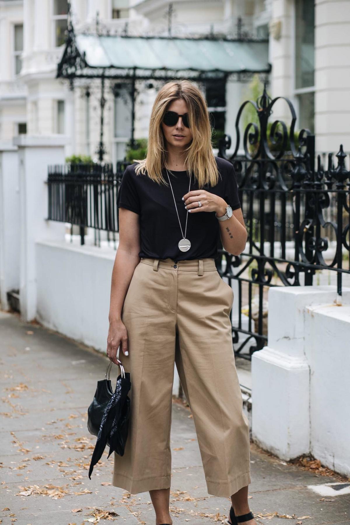basic black t shirt, cropped wide leg camel trousers, wedge sandals, bag with ring handle and bandana, chic summer outfit, silver long disc necklace, round sunglasses