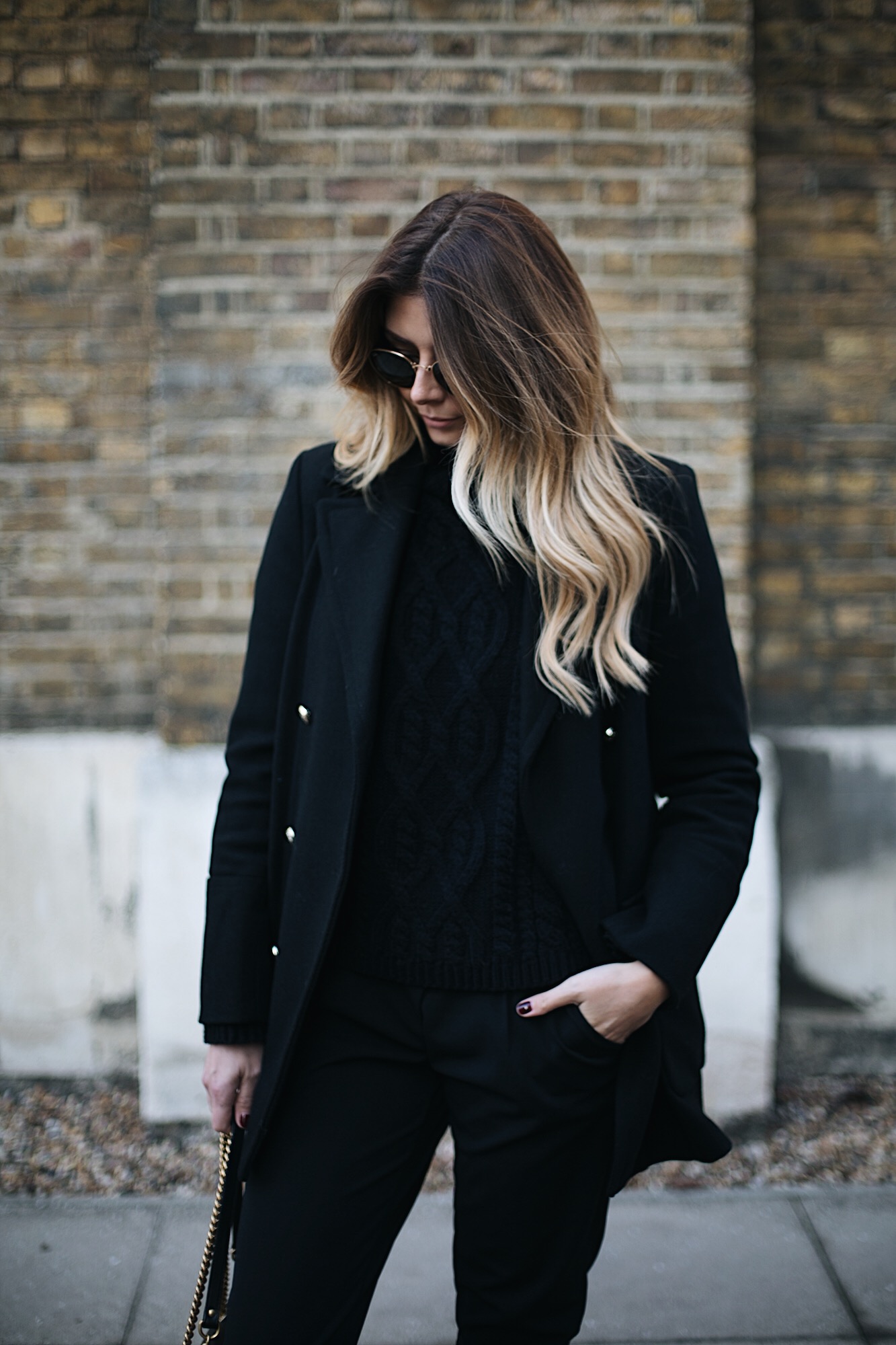long blonde balayage hair, black military jacket coat, black sweater, black jeans, all black outfit
