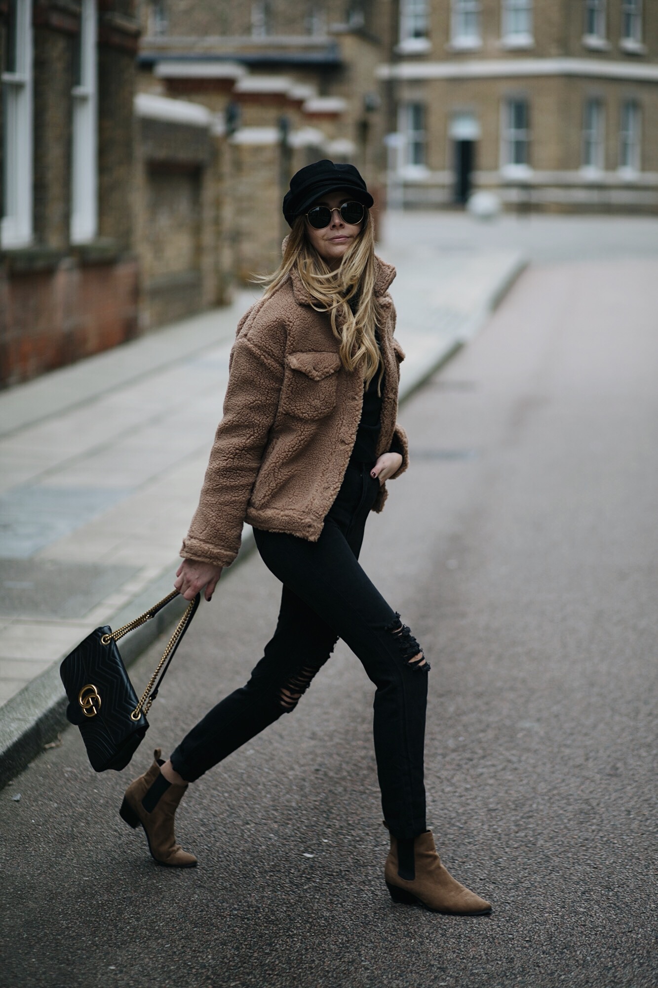 Emma Hill wear camel teddy jacket, ripped black jeans, Gucci Marmont bag, Rayban round gold sunglasses, tan suede Chelsea ankle boots, black baker boy cap hat. Casual Winter outfit