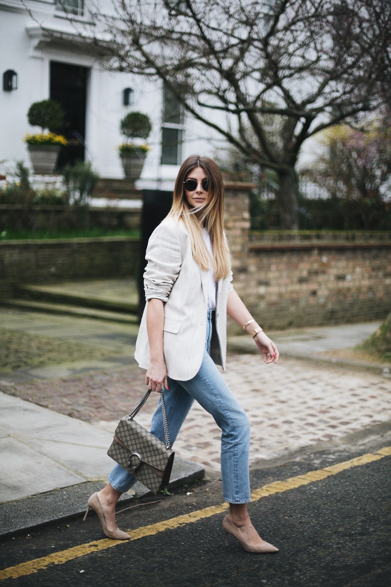 Emma Hill of EJStyle wears beige linen blazer, light wash high waisted jeans, Gucci medium beige Dionysus bag, small arm tattoo, rose gold accessories, beige suede Jimmy Choo pumps, spring outfit