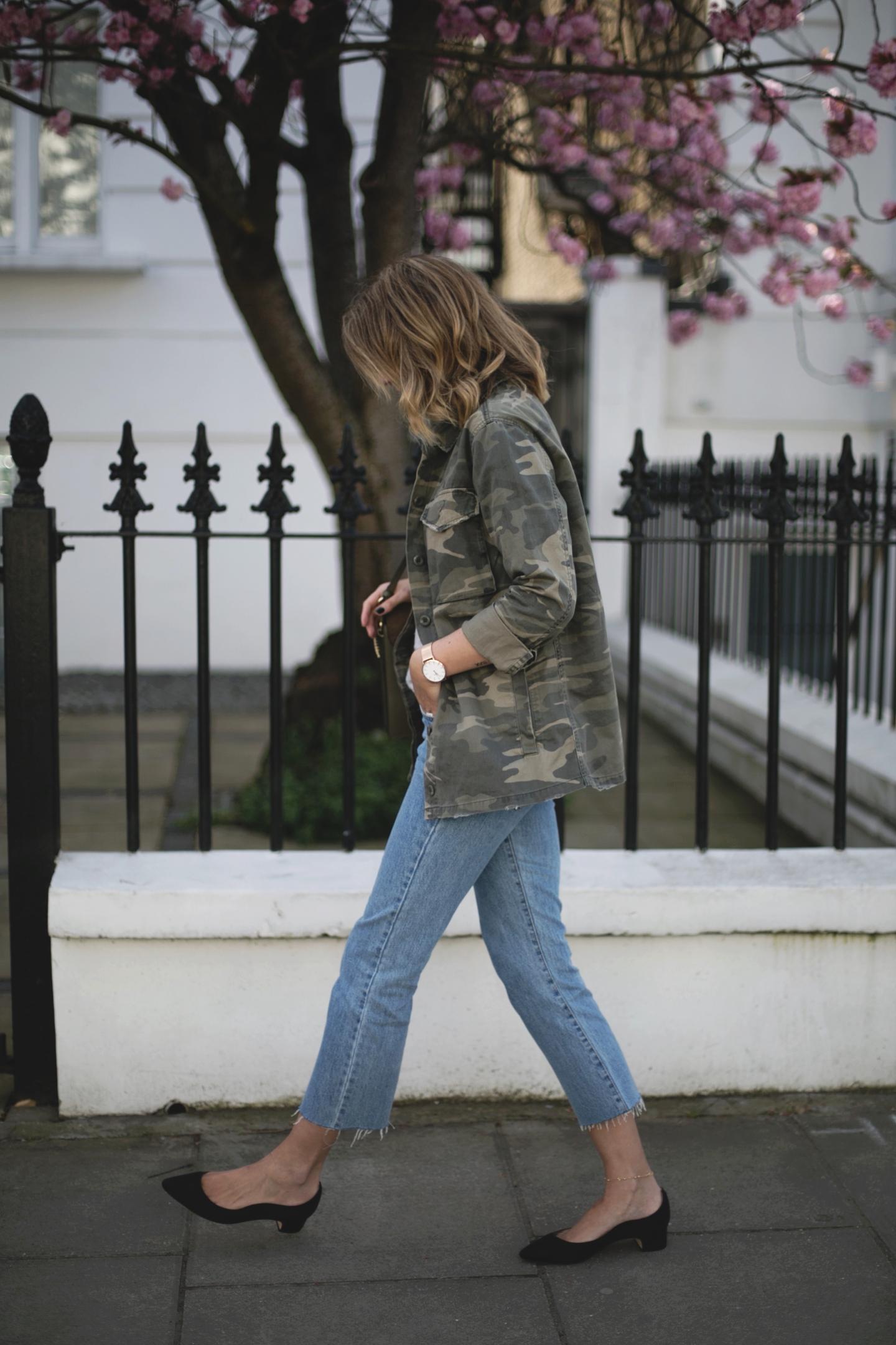 Emma Hill wears camouflage jacket, grey linen t-shirt, khaki Chloe Faye bag, cropped frayed hem light wash jeans, Dune x Rupert Sanderson low block heels, round Rayban sunglasses, gold jewellery, casual Spring outfit