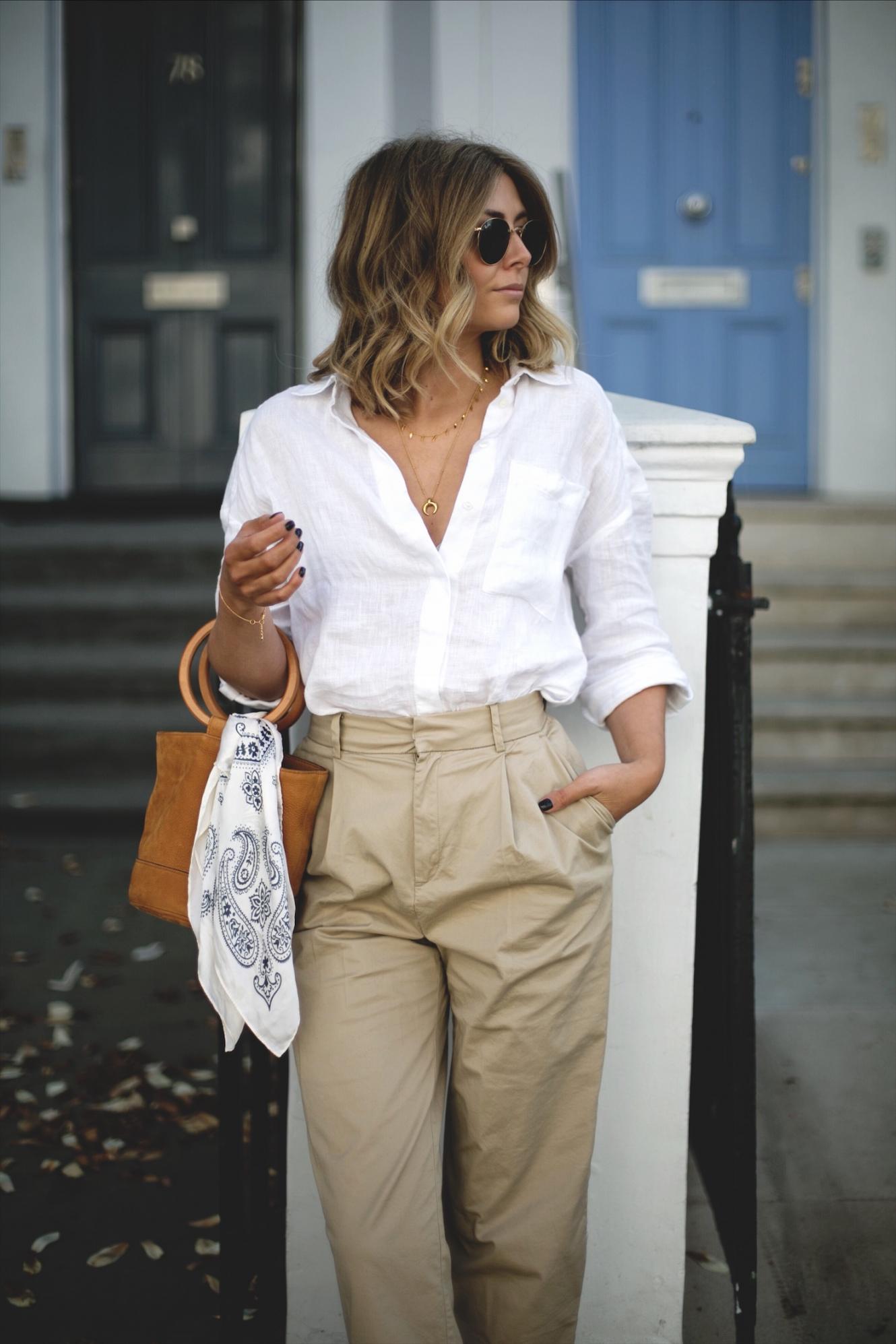 Emma Hill wears white linen shirt, beige chinos, natural wedge espadrilles, tan suede Simon miller bonsai bag with ring handle, chic spring outfit