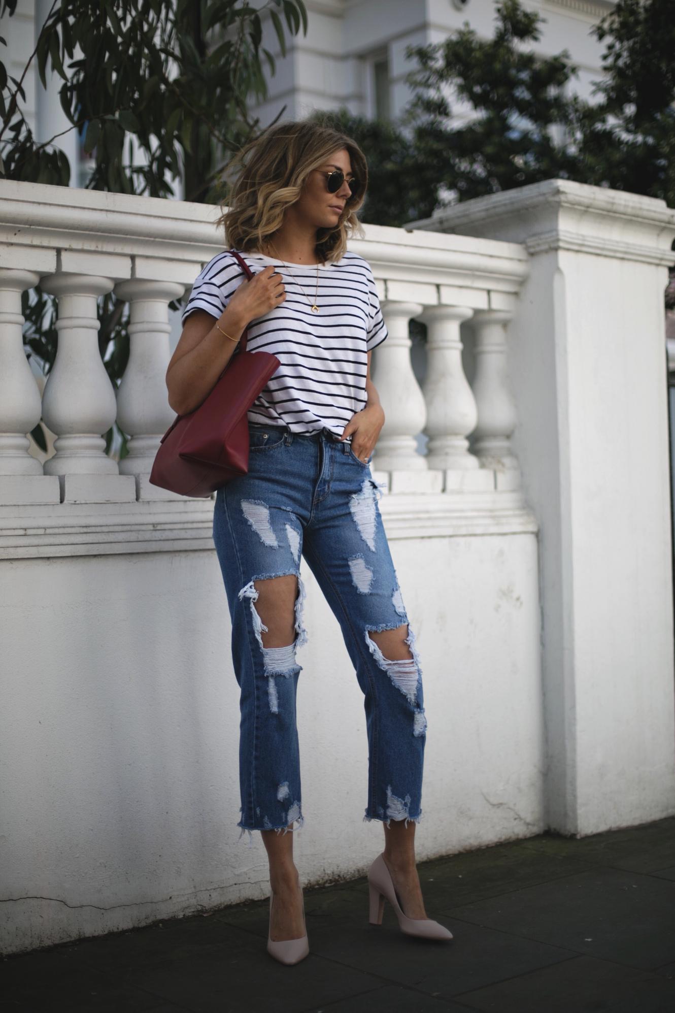 Emma Hill of EJSTYLE wears stripe t-shirt, ripped destroyed jeans, red Saint Laurent YSL shopper tote bag, nude heels, gold layered necklaces, Spring outfit