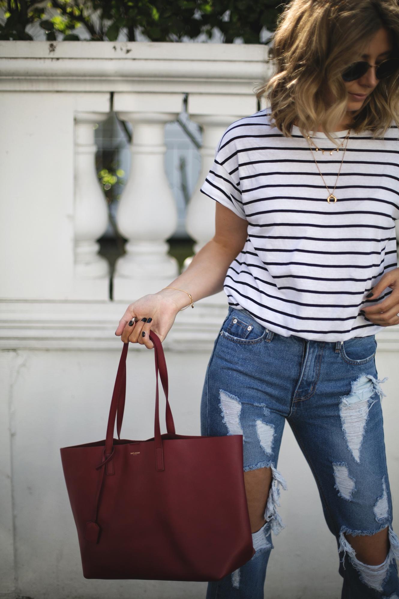 Emma Hill of EJSTYLE wears stripe t-shirt, ripped destroyed jeans, red Saint Laurent YSL shopper tote bag, gold layered necklaces, Spring outfit