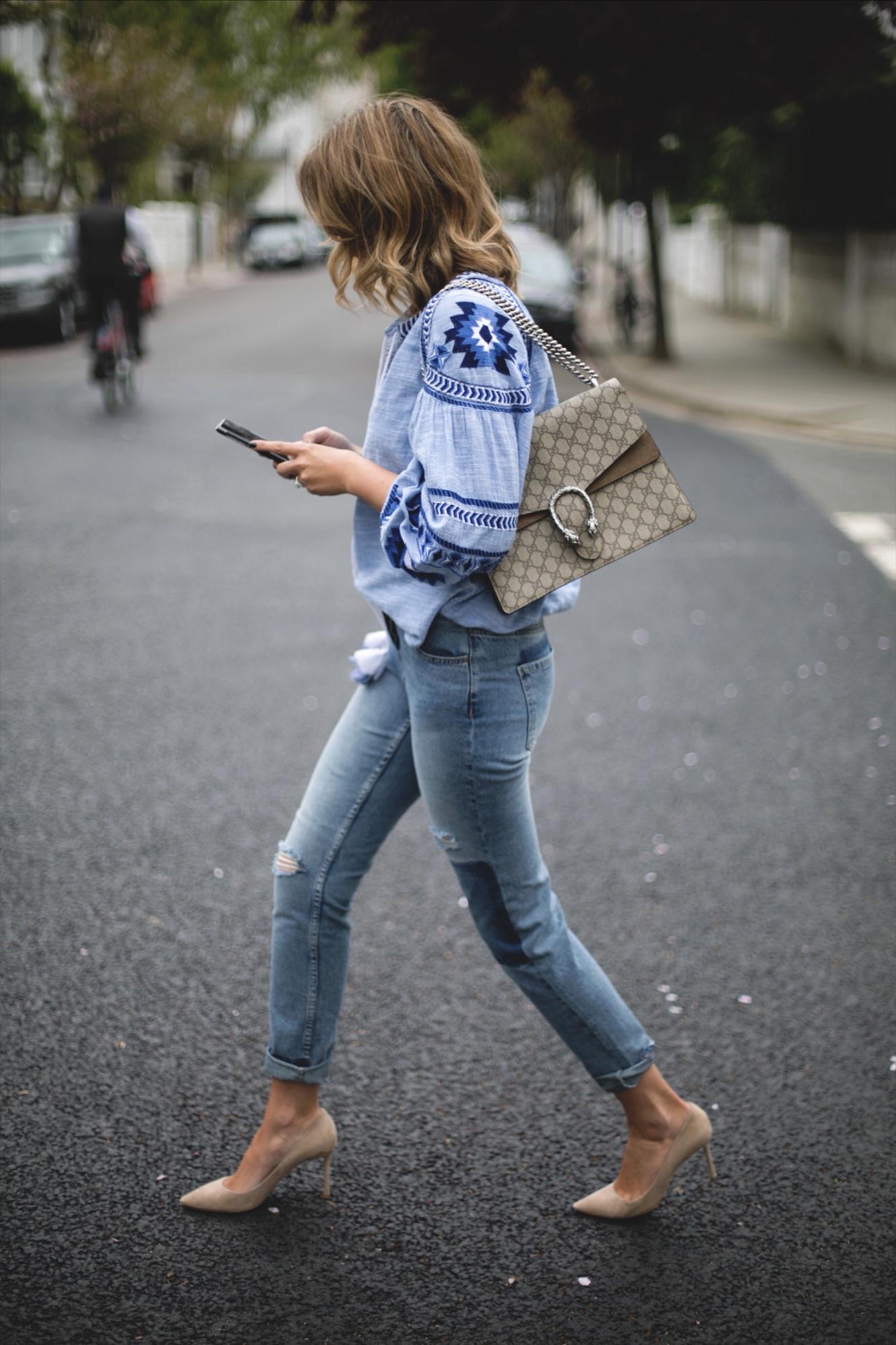 Emma Hill wears embroidered blue top with balloon sleeves, cuffed mid wash jeans, street style photography tips