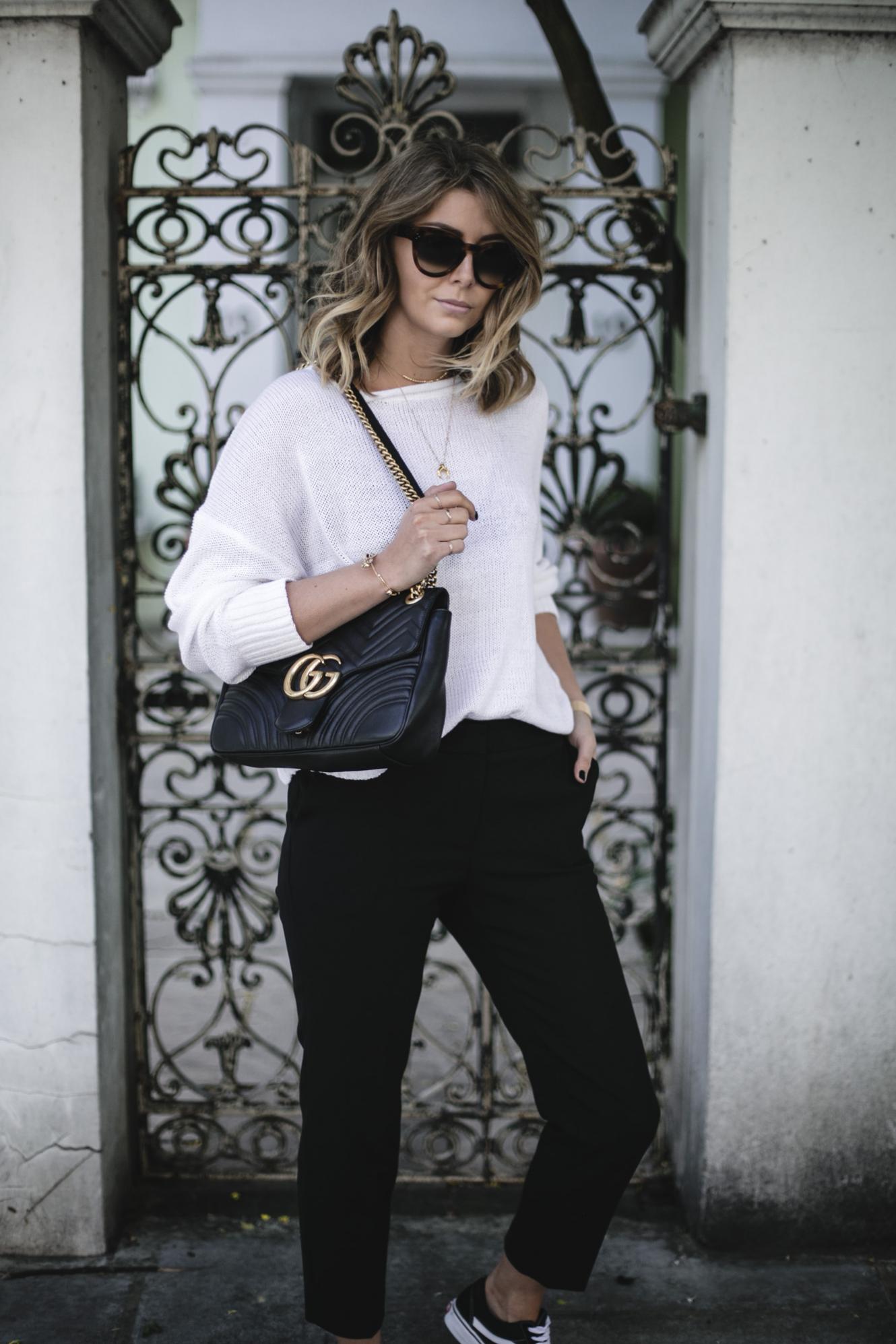 Emma Hill wears Vans old skull, white summer knit, black tailored trousers, Gucci Marmont bag, casual Spring outfit