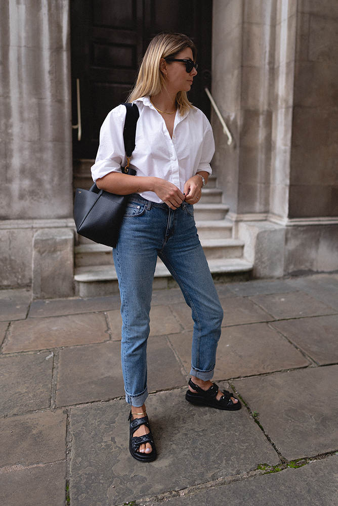 Emma Hill style. crisp white shirt, Chanel black quilted leather dad sandals, straight leg jeans, Celine Seau Sangle bag, Ray-Ban Meteor sunglasses, casual Summer outfit