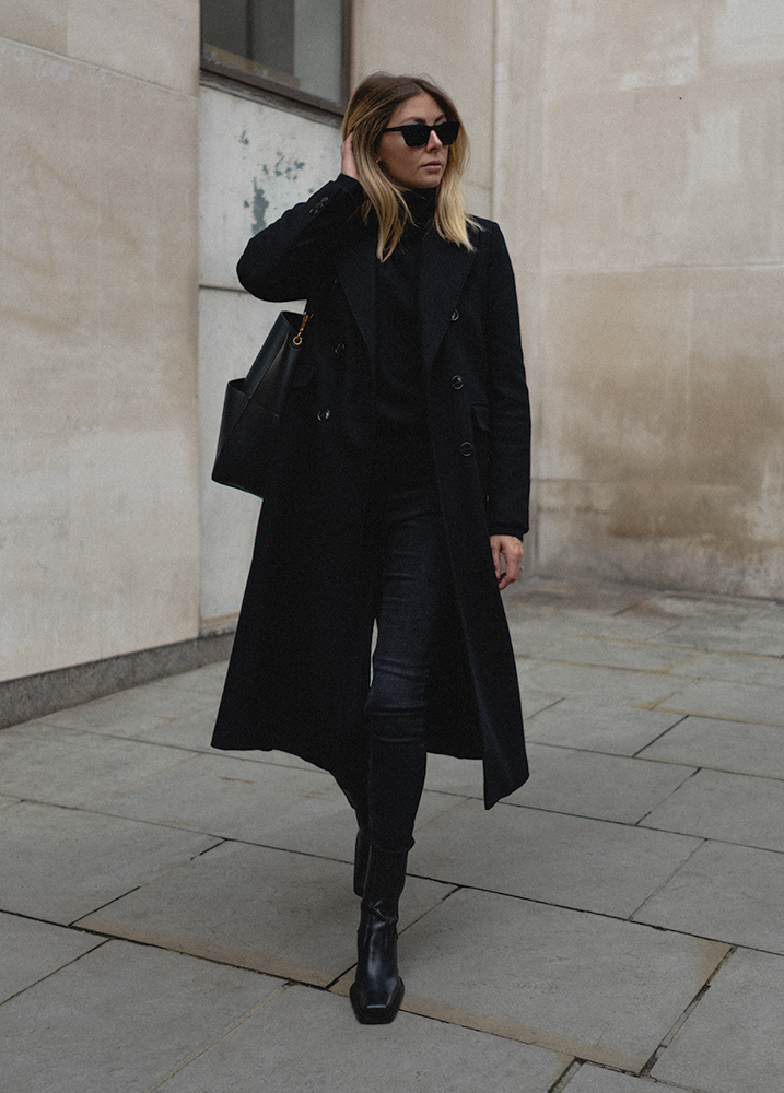 Emma Hill Autumn style. Black tailored wool long coat, black square toe ankle boots, skinny jeans, high neck jumper. All black outfit. Autumn Winter outfit