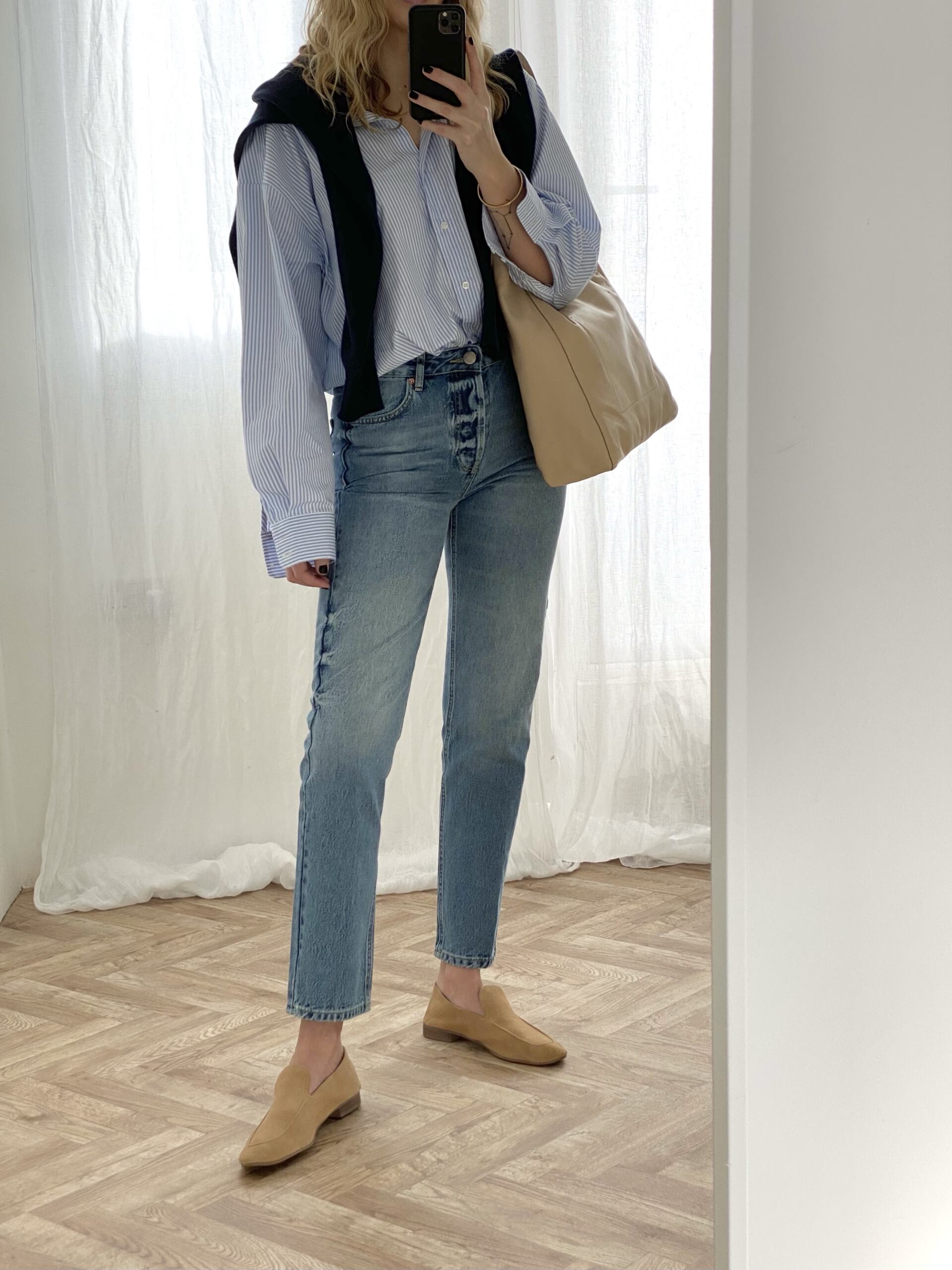 Blue stripe shirt, mid wash straight leg jeans, jumper worn over shoulders, camel suede loafers, cream leather bag, Spring outfit.