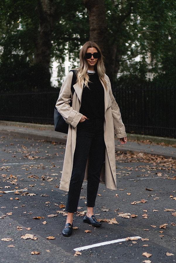 Emma Hill style. Beige trench coat, black jumper layered over a white t-shirt, black cropped jeans, Gucci loafers, Celine Seau Sangle bag, Celine Baby Audrey sunglasses. Chic autumn fall outfit blog