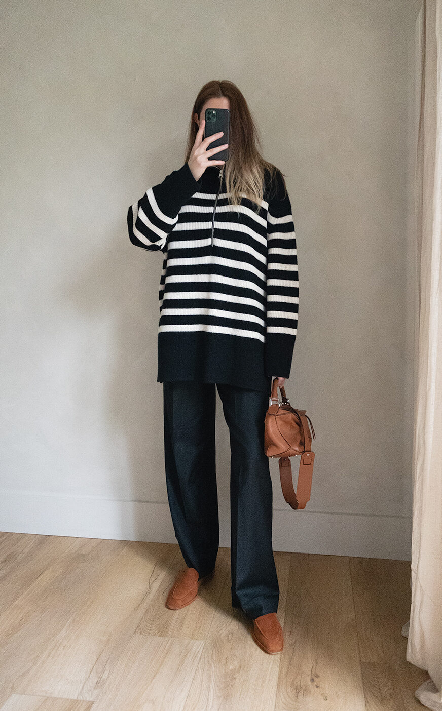 Emma Hill style. Black white stripe half zip chunky jumper sweater, black tailored trousers, tan leather small Loewe Puzzle bag, tan suede loafers. Chic Spring outfit