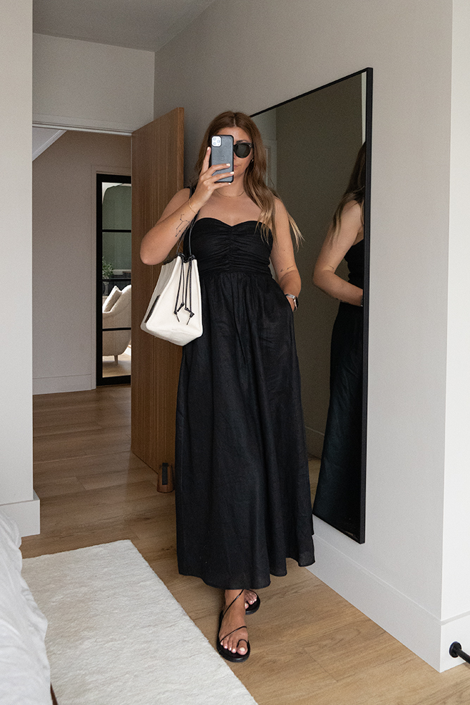 Emma Hill style. Black linen strapless bandeau midi dress, Celine Baby Audrey sunglasses, Loewe canvas cushion bagg, black ancient greek sandals.