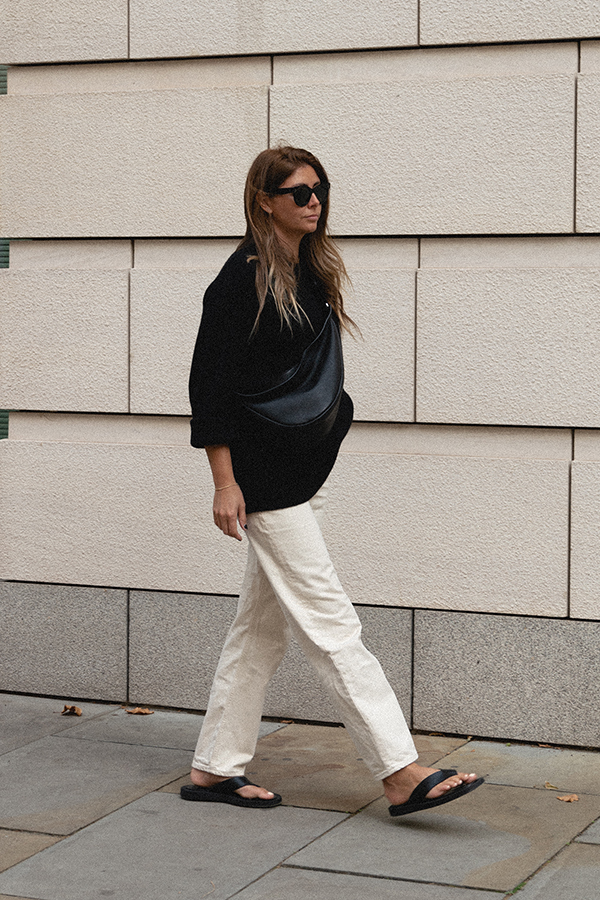 BLOG Emma Hill style, The Row slouchy banana bag black large, Celine Baby Audrey sunglasses, off white ecru baggy tapered jeans, black cashmere oversized jumper, black thong sandals. Transitional outfit