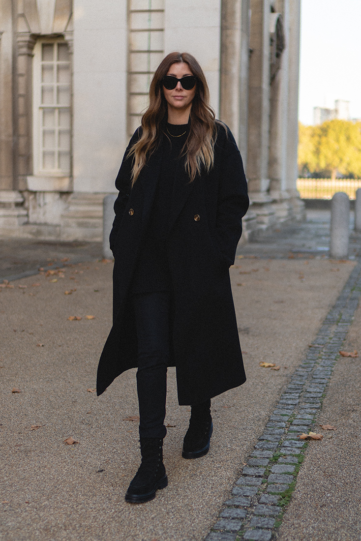 BLOG Emma Hill style. All black outfit. The Curated black London coat, black skinny fit trousers, suede lace up Winter boots. Chic autumn fall outfit