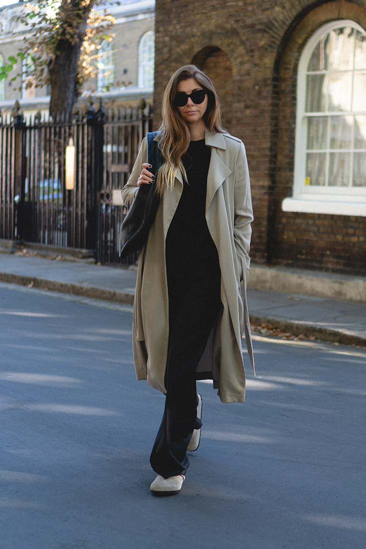 BLOG Emma Hill style. Beige trench coat, black wide leg tailored trousers, Birkenstock Boston taupe suede clogs, The Row Everyday bag, black jumper, Celine sunglasses. Minimalist autumn fall outfit