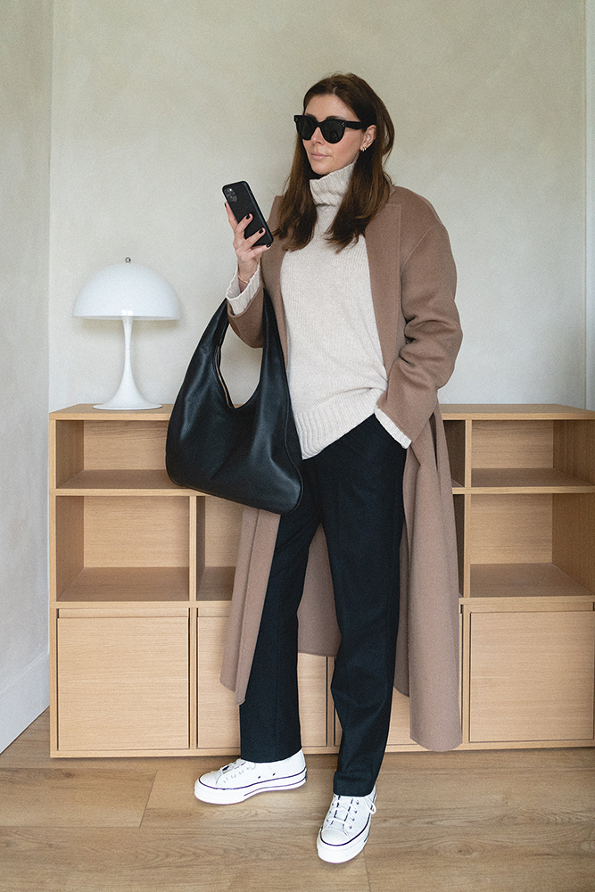Emma Hill style. Winter outfit. Camel wool coat, beige jumper, black tailored trousers, leather fleece Converse trainers, The Row Everyday bag, Celine Baby Audrey sunglasses. Minimal style